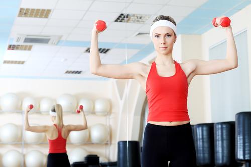 Vrouw doet oefeningen met dumbbells