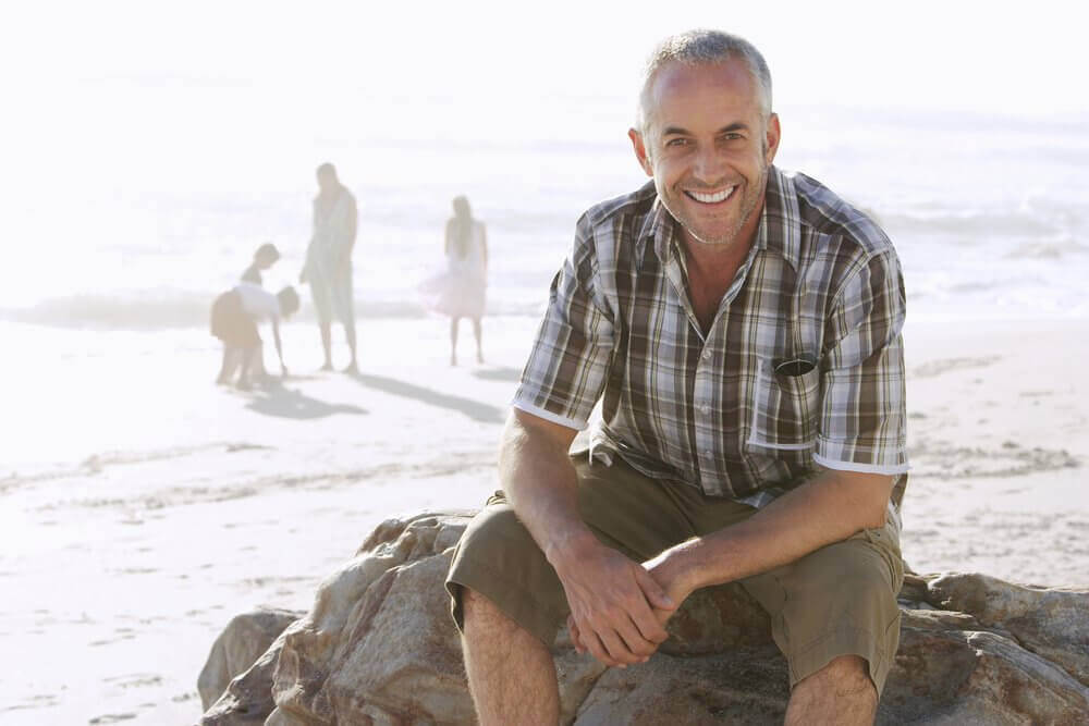 Man met familie op strand