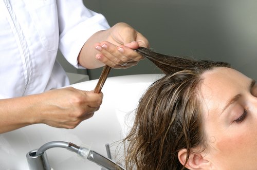 Vrouw krijgt hoofdhuidmassage