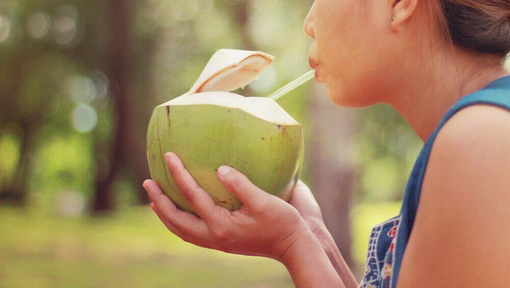 Vrouw drinkt uit kokosnoot