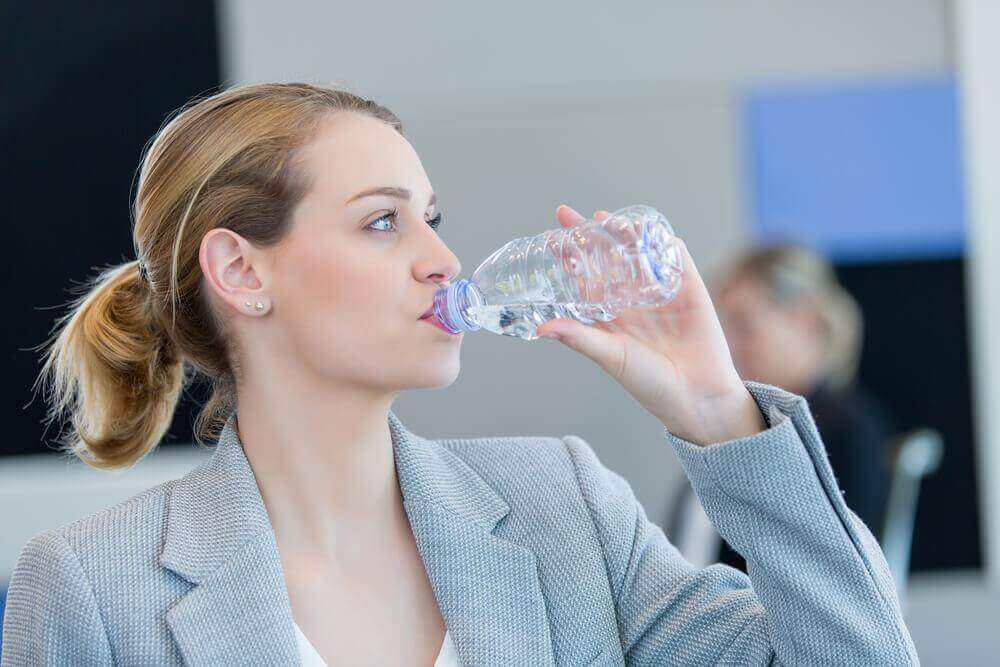 vrouw drinkt flesje water