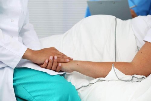 Dokter die hand zwangere vrouw vasthoudt