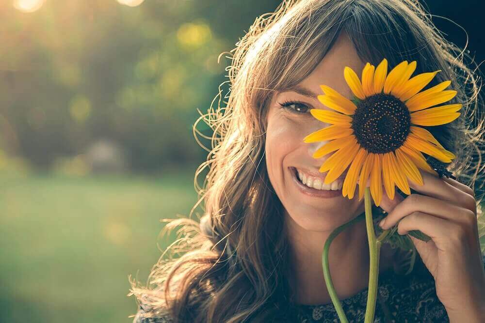 lachende vrouw met een zonnebloem
