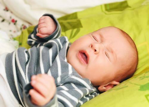 Huilende baby op een groen kussen
