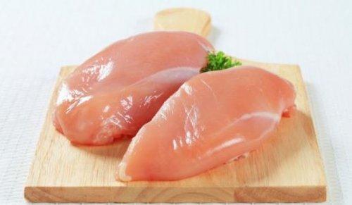 Twee stukken kipfilet op een snijplank