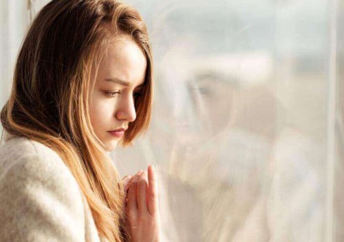 Eenzame vrouw leunt tegen het raam