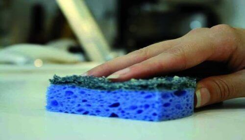 Het aanrecht schoonmaken met een spons