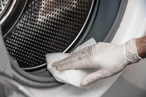 Vrouw die wasmachine schoonmaakt