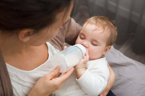 Een baby krijgt de fles van de moeder