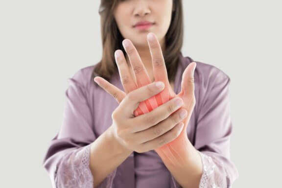 Vrouw heeft pijn in de gewrichten van haar hand
