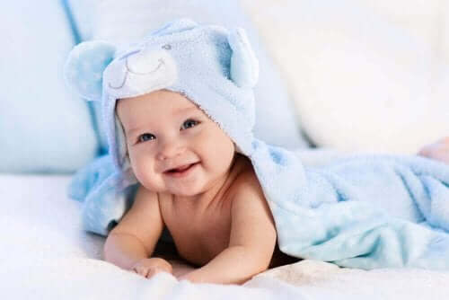 Een lachende baby onder een deken