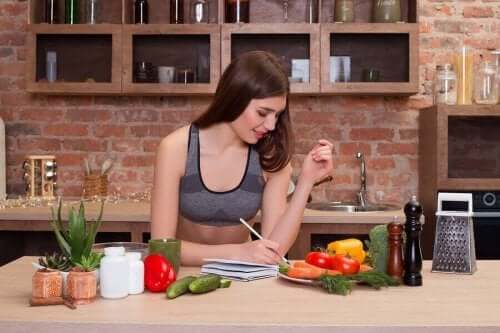 Vrouw schrijft een recept op aan de keukentafel