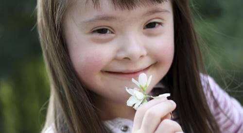 meisje ruikt aan witte bloem