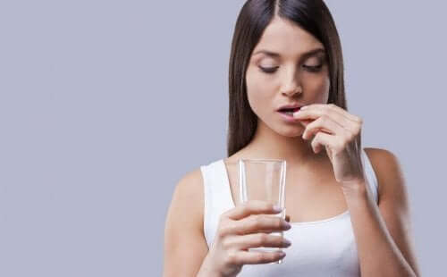 Vrouw neemt de morning-afterpil in met een glas water