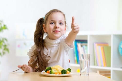 Meisje is blij met haar bord met groente