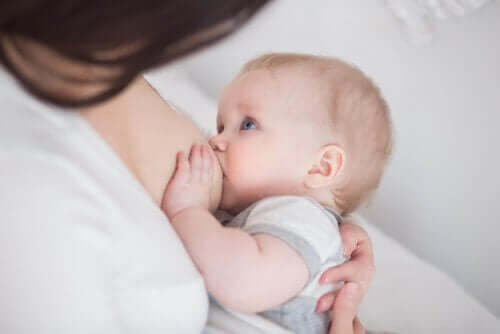 Een moeder die haar baby borstvoeding geeft
