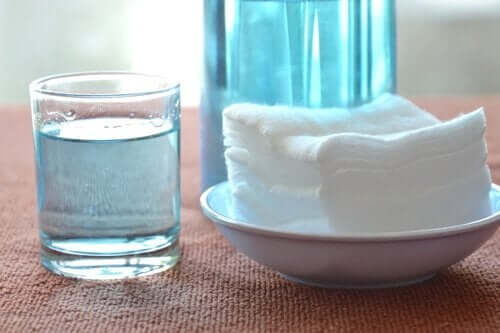 Glas met waterstofperoxide en handdoeken