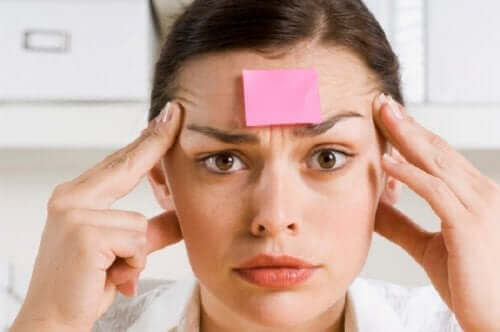 Een vrouw met een post-it op haar voorhoofd