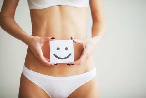 Een vrouw houdt een smiley voor haar buik