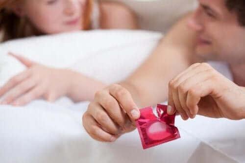 Een man scheurt een condoomverpakking open