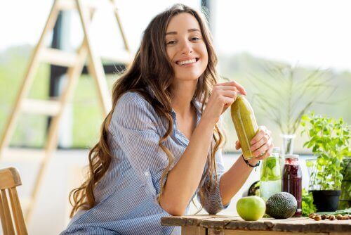 Een vrouw drinkt een groene smoothie