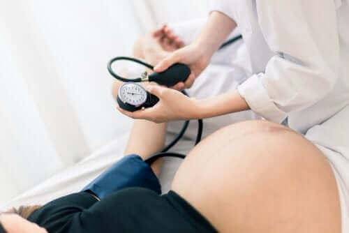 Een arts neemt de bloeddruk van een zwangere vrouw