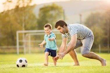 Vader en zoon aan het voetballen