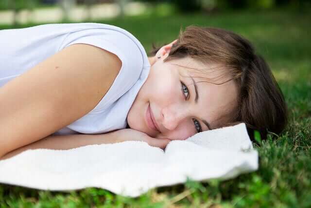 Vrouw ligt te relaxen op het gras