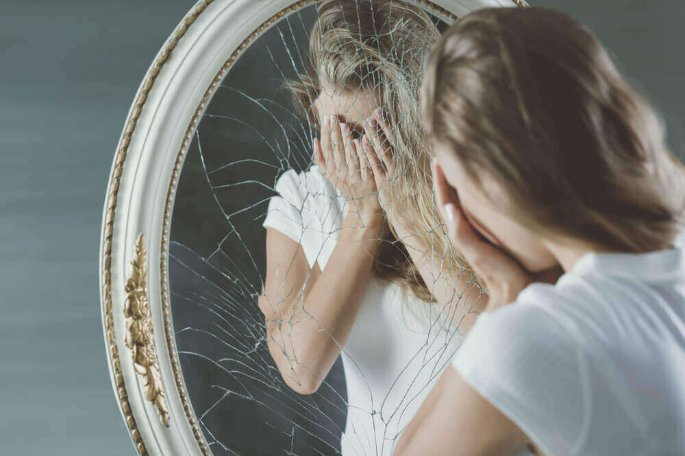 Vrouw bij een kapotte spiegel