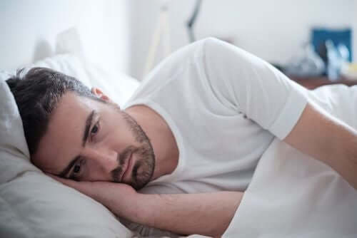 Een man ligt op bed en is depressief