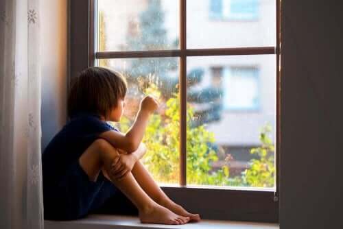 Een kind kijkt uit het raam