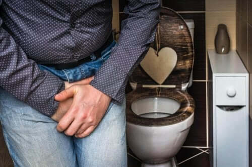 Een man drukt de handen tegen zijn blaas