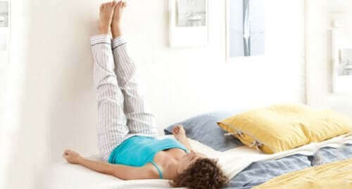 Vrouw houdt benen omhoog tegen de muur