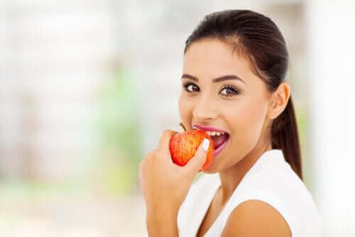 Vrouw eet een rode appel