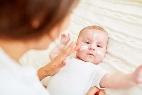 Een baby met crème op het gezicht