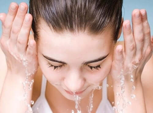 Een vrouw wast haar gezicht met water