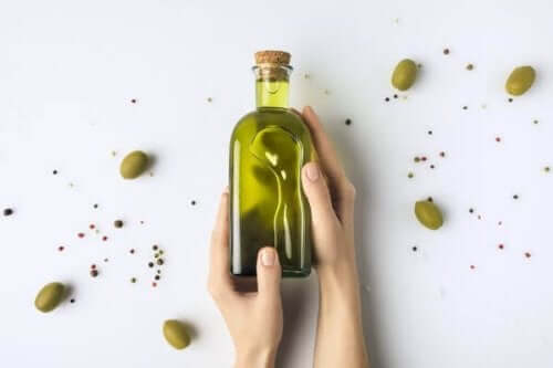 Olijfolie in een fles met olijven eromheen