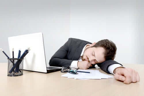 Een man valt in slaap op zijn werk