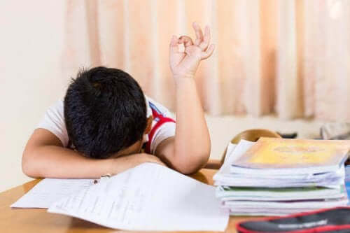 Een vermoeid kind leunt op zijn huiswerk