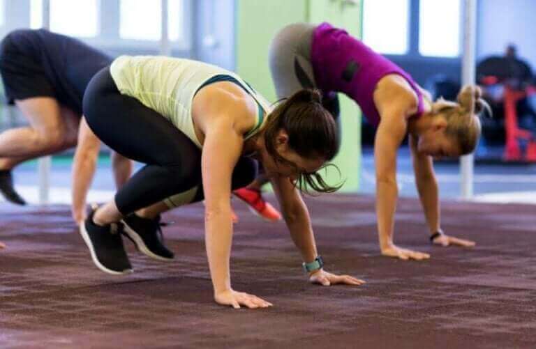 Groep vrouwen die burpees doen om fit te blijven