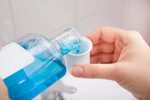 Iemand schenkt mondwater in een dop