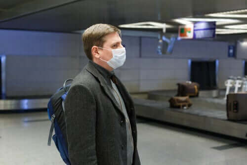 Man met een masker op een luchthaven