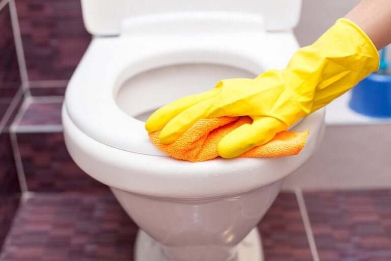 Iemand maakt een toilet schoon
