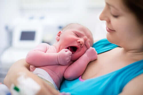 Een geeuwende baby bij moeder op de borst