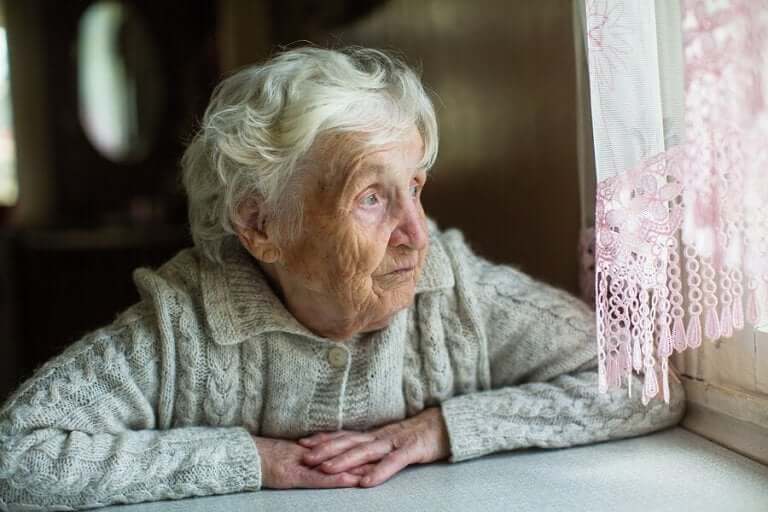 Bejaarde vrouw kijkt uit het raam