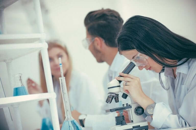 Iemand bekijkt iets onder een microscoop
