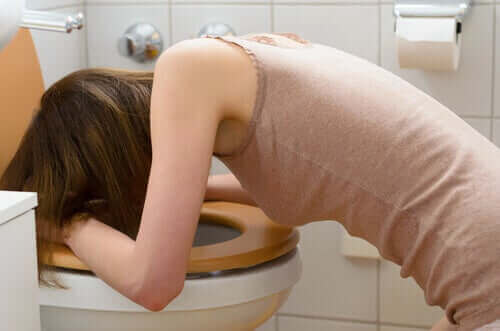 Vrouw is op het toilet aan het braken