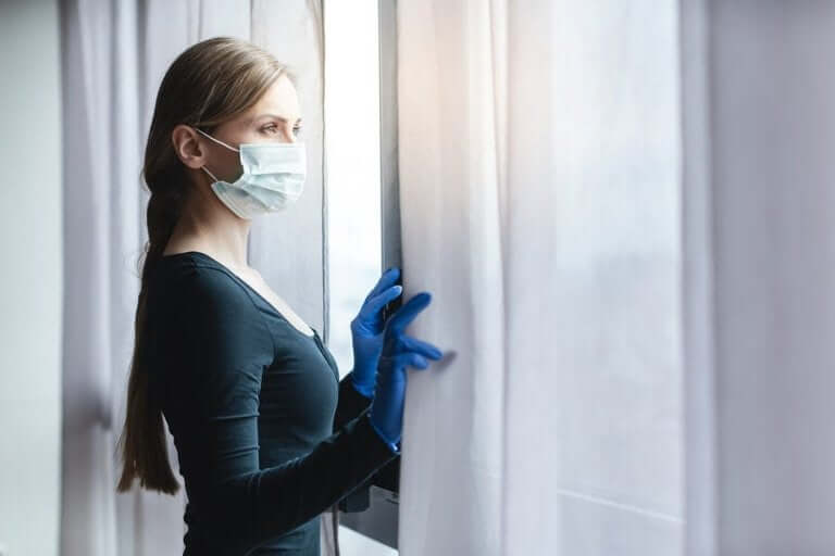 Vrouw met een masker bij een raam