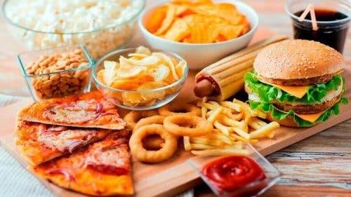 Een plank met fastfood en ongezonde snacks