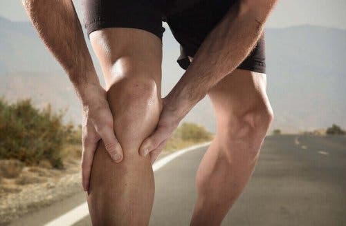 Een man grijpt naar zijn knie